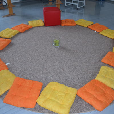 Bild vergrößern: Ein Sitzkreis aus Kissen auf dem Boden des Klassenzimmers